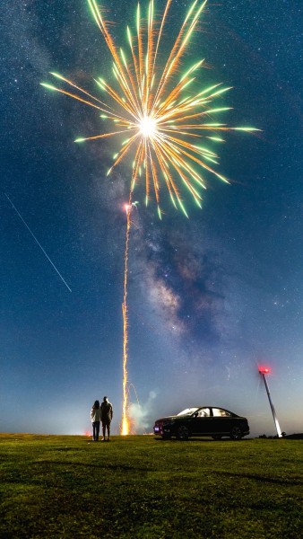 烟花在流星雨和银河之下绽放。